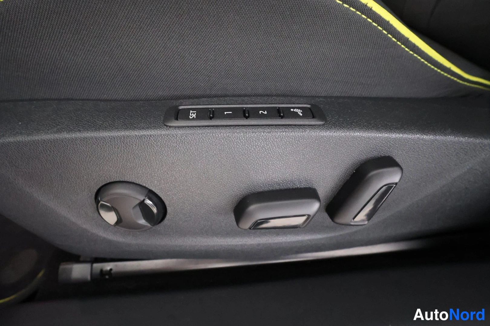 Yksityiskohta: Close-up of an electric seat adjustment panel on a door sill. A control strip shows 'SET', '1', and '2' buttons for memory function. Below are a joystick knob a