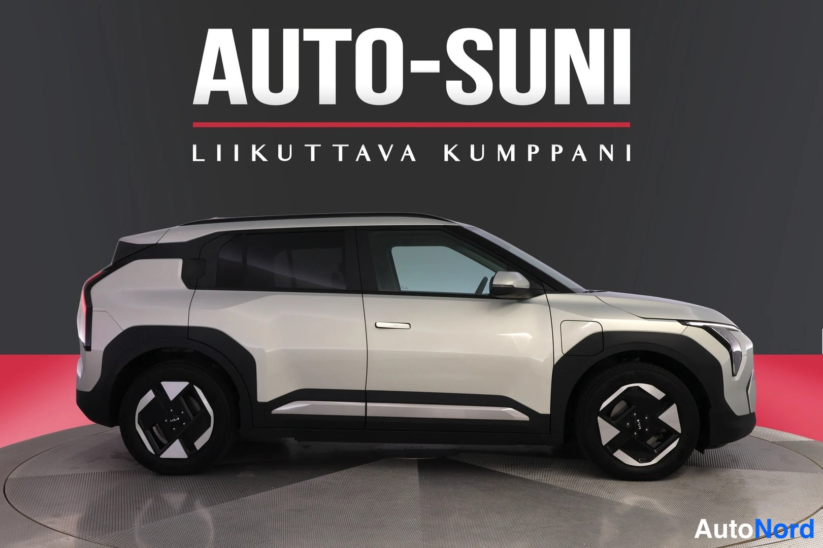 Etuviisto, nokka oikealle: Valkoinen Kia EV3 esitään melkein suorasta sivukuvasta, keula oikealla ja pyöriä sekä tummat korimuovit näkyvät.