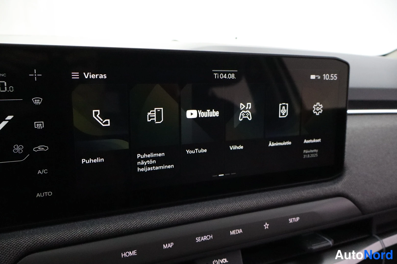 Sivulta: Kuvassa auton infotainment-näytön sovellusvalikko, jossa ovat kuvakkeet 'Puhelin', 'Puhelimen näytön heijastaminen', 'YouTube', 'Viihde', 'Äänimuistio' ja 'Aset