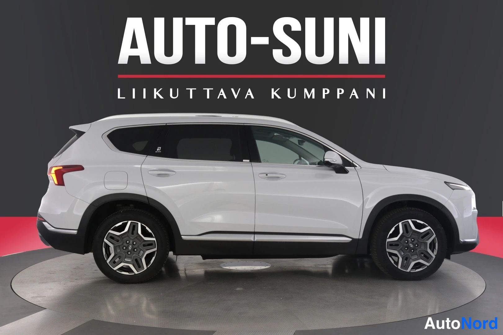 Takaviisto: Hyundai Santa Fe -maasturi sivulta kuvattuna, valkoinen, takaosan vasemmat takavalot syttyvät, kuvattuna auton vasemmalta puolelta.
