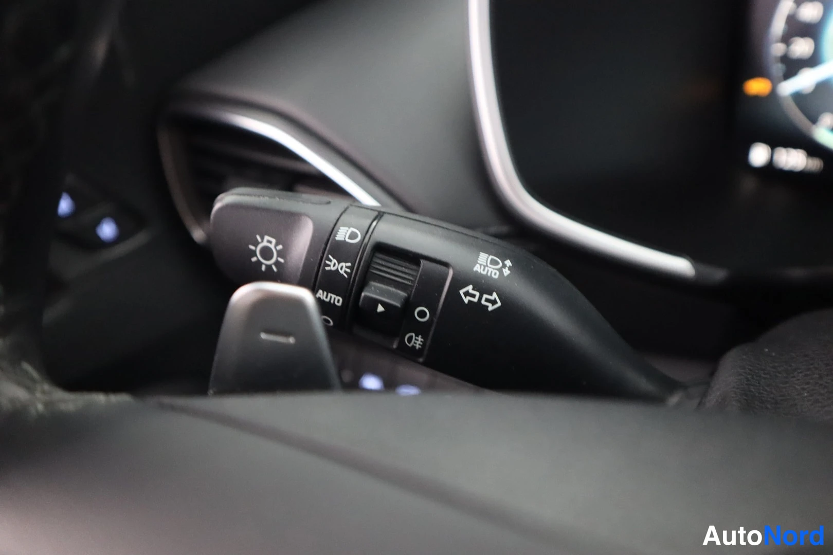 Yksityiskohta: Hyundai Santa Fe -henkilöauton valojen ja suuntavilkun vivut, AUTO-merkinnällä, taustalla tumma kojelauta.