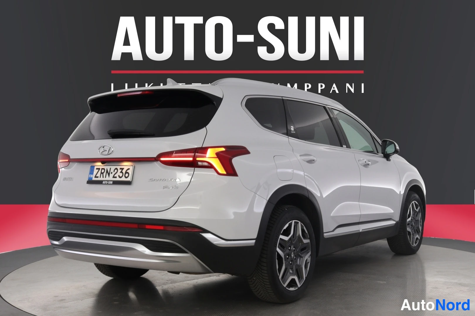 Takaviisto: Hyundai Santa Fe -maasturi takaa oikealta sivulta kuvattuna, valkoinen, takavalot syttyvät, rekisterikilpi.