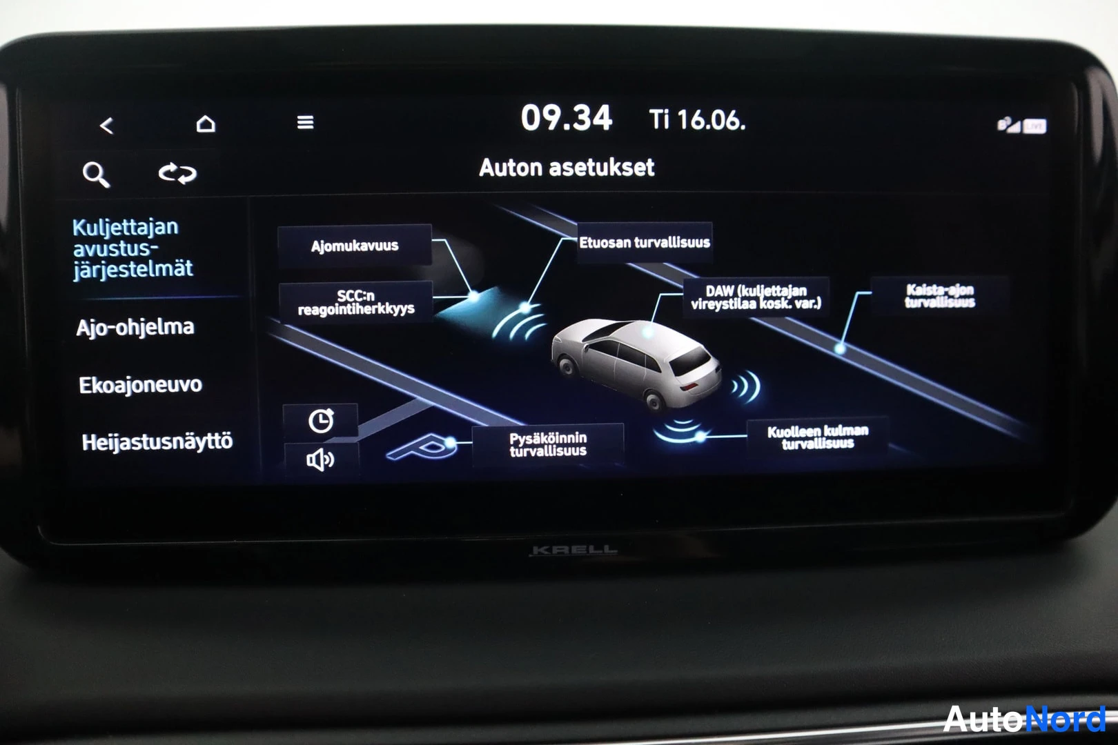 Yksityiskohta: Infotainment-näyttö valikossa 'Auton asetukset', kuljettajan avustusjärjestelmien asetukset suomeksi; näytön alareunassa KRELL-teksti.
