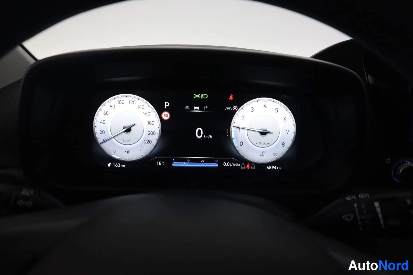 Edestä: Auton digitaalinen mittaristo: P-vaihde, 0 km/h, kulutus 8,0 l/100 km ja kokonaismatka 6894 km.