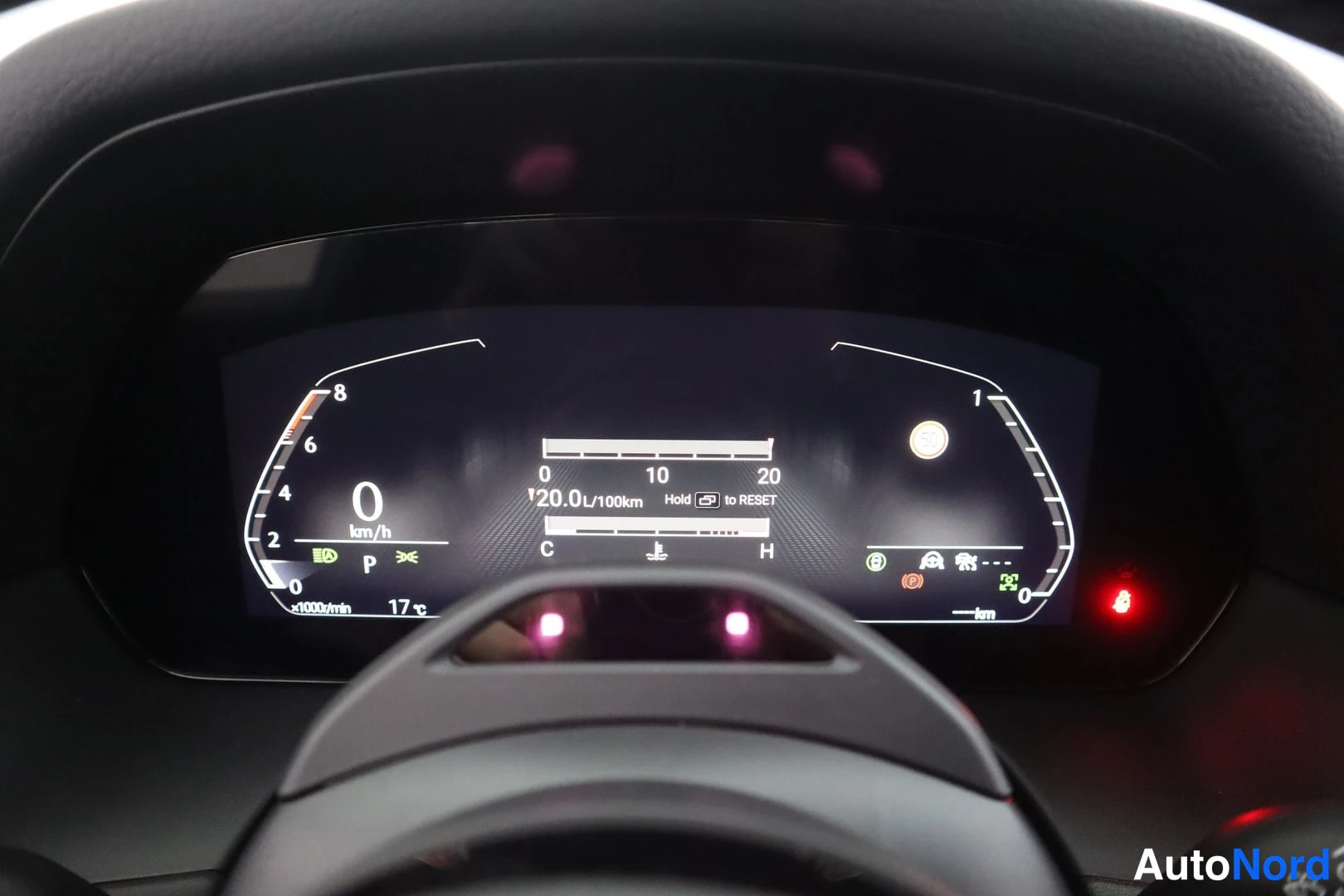Muu: Digitaalinen mittaristo lähikuvassa: nopeus 0 km/h, vaihde P, kulutus 20,0 l/100 km, ulkolämpötila 17 °C ja varoitusvaloja.