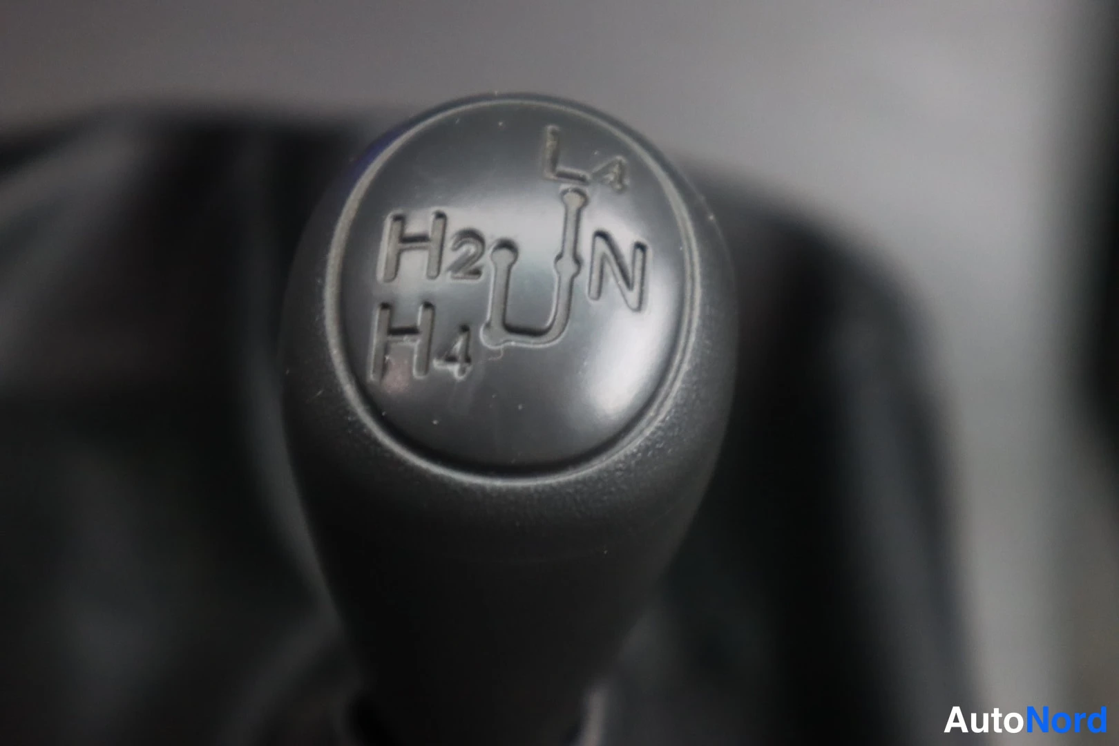 Muu: Lähikuva nelivetoajoneuvon alavaihdekepistä, jonka nupissa merkinnät H2, H4, N ja L4.