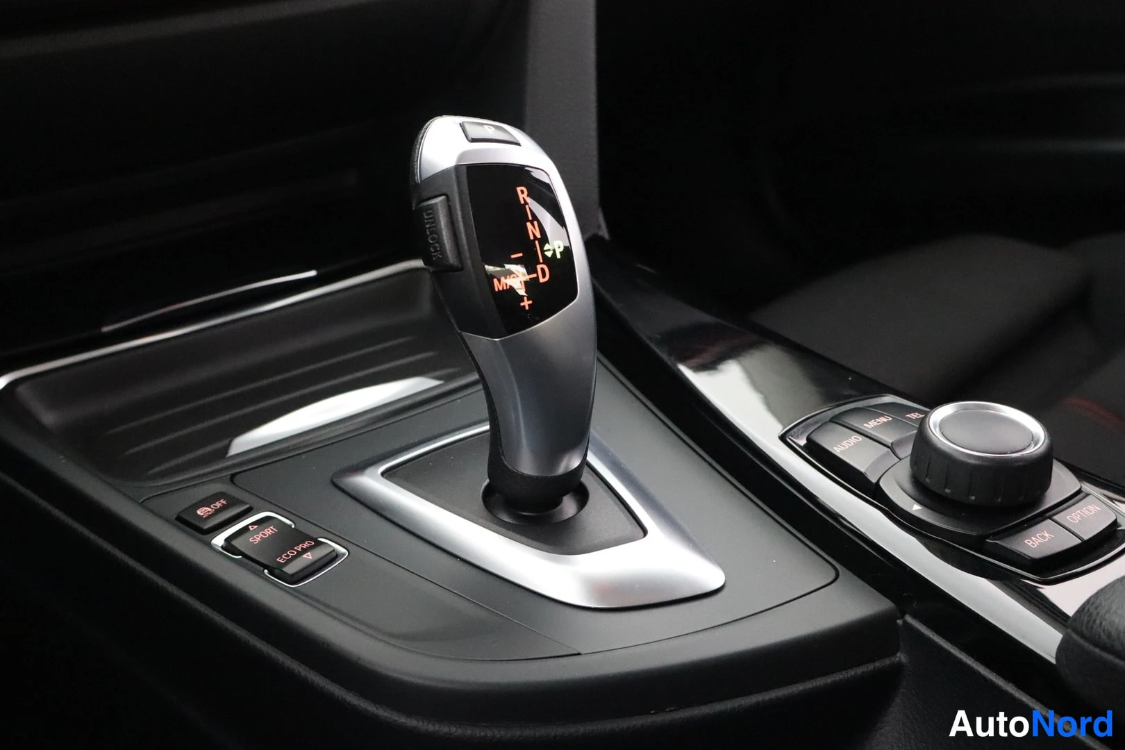 Muu: Automaattivaihteenvalitsin ja iDrive-ohjain keskikonsolissa, kojelukitus näyttää vaihteet P R N D M/S + ja −.