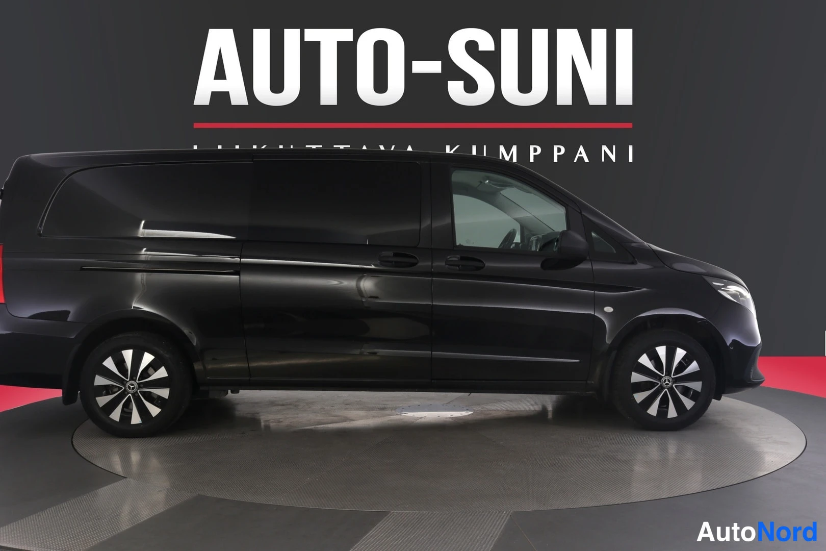 Sivulta: Mustan Mercedes-Benz Vito -pakettiauton sivuprofiili, kylki ja molemmat pyörät näkyvissä.