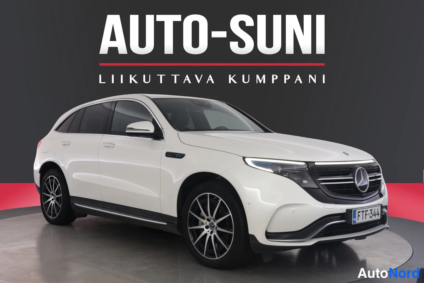 Etuviisto, nokka oikealle: Valkoinen Mercedes-Benz EQC kulmauspäin oikealta valokuvastudion pyörivällä alustalla, rekisteritunnus.
