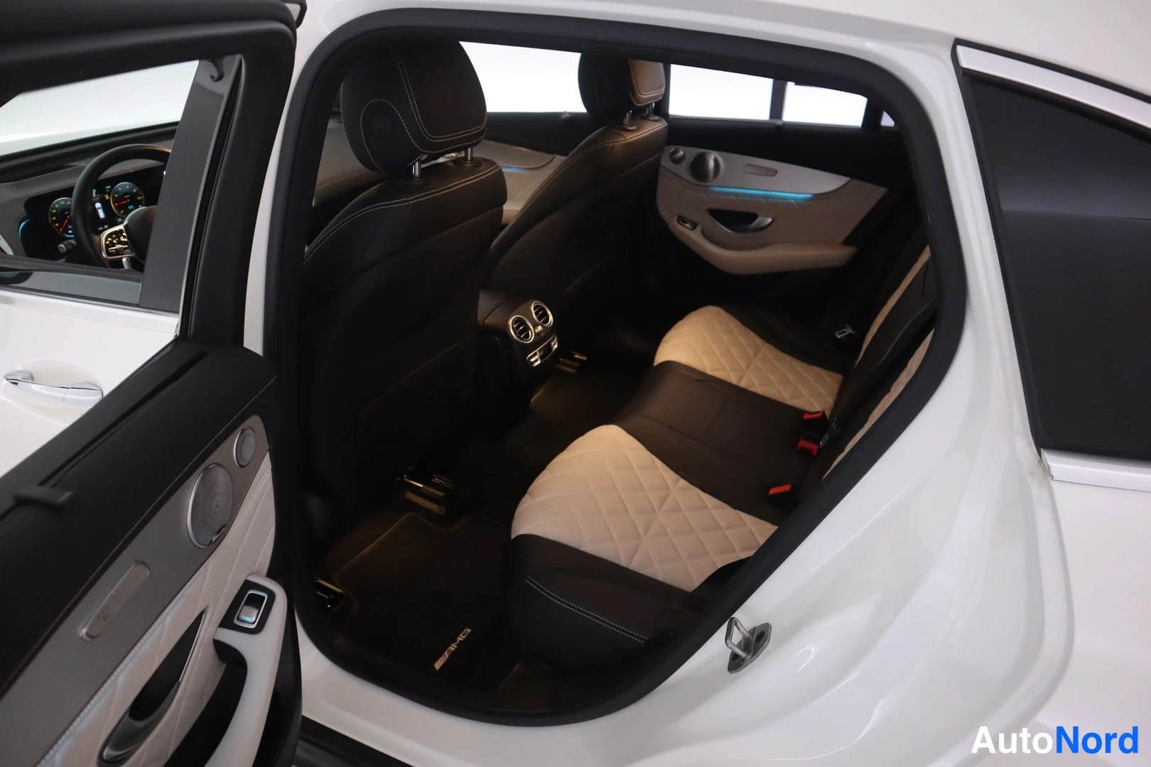 Yksityiskohta: Mercedes-Benz EQC:n takaistuimen tila avoimesti oikean oven kautta; tumma ja beige quilted-punottu nahkapenkkien verhoilu.