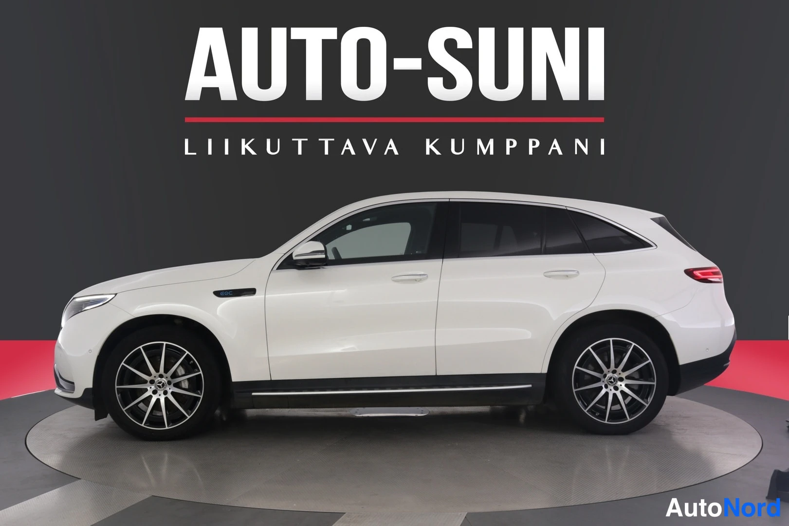 Sivulta: Mercedes-Benz EQC:n sivukuva sisätiloissa; valkoinen koripanelointi ja tummat vanteet näkyvät.