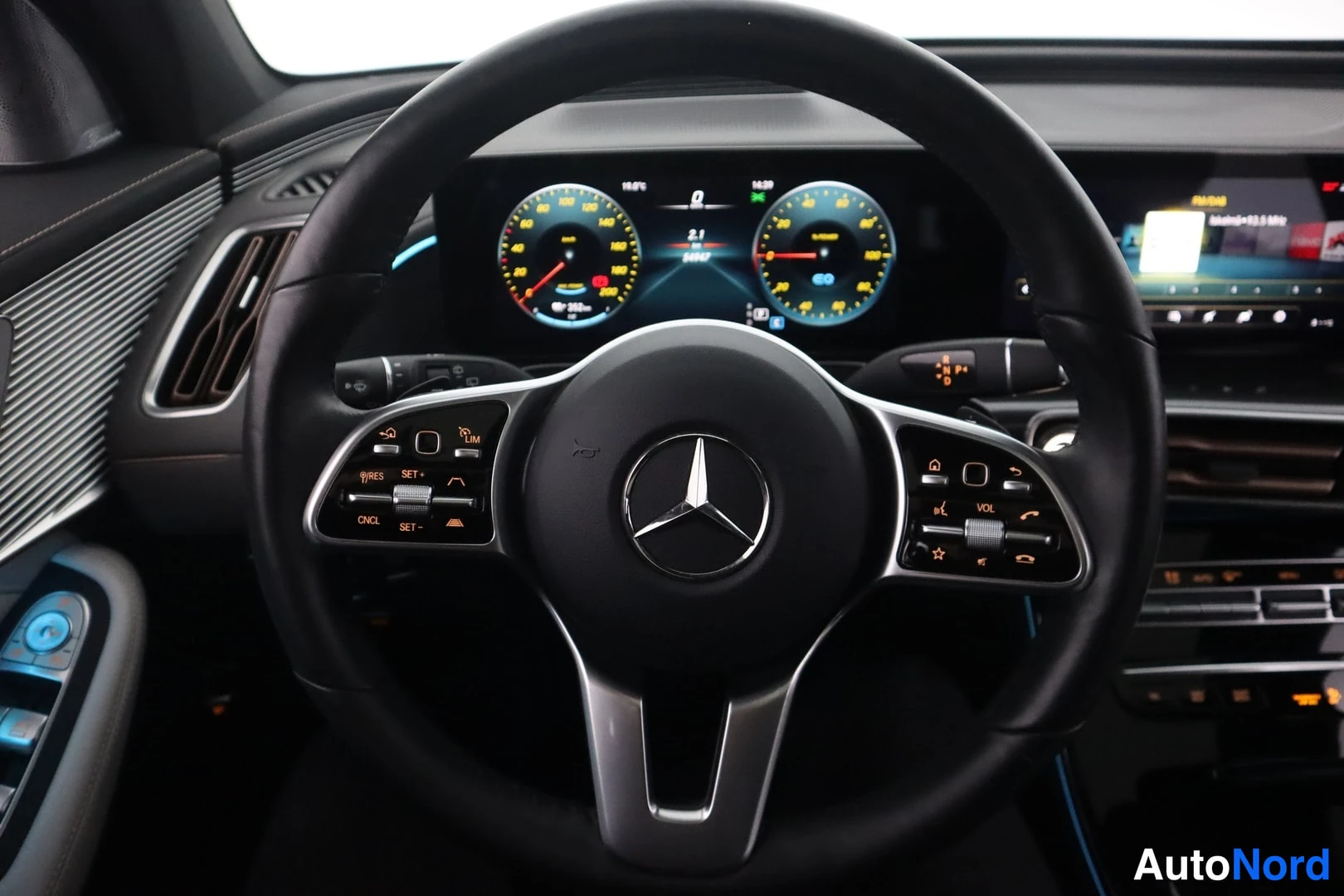 Edestä: Ohjauspyörä Mercedes-tunnuksella kohtaa digitaalisen mittariston, jonka napeissa textaat RES+, CNCL ja SET.