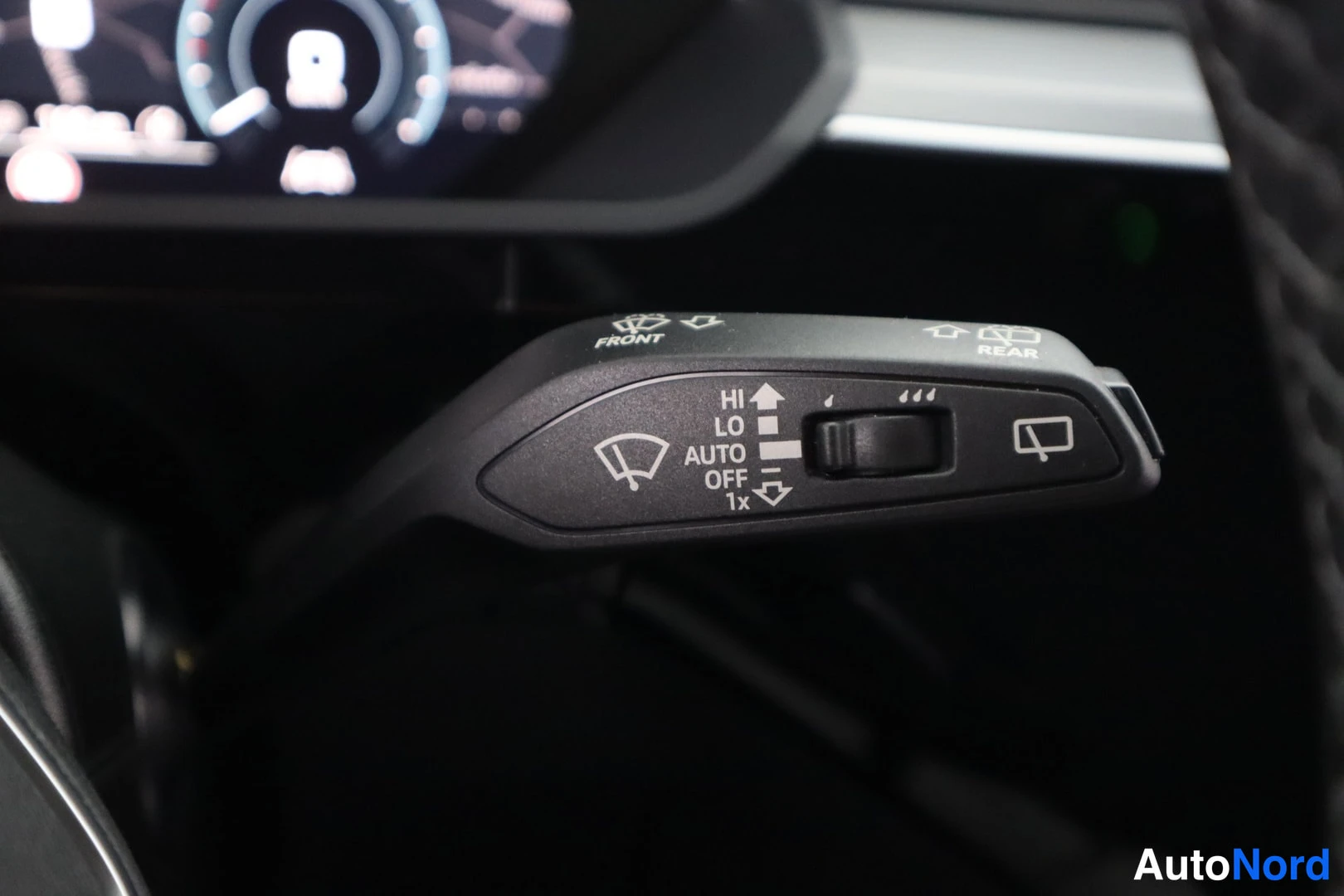 Yksityiskohta: Tuulilasinpyyhkijöiden vivut ja asentojen merkkinnät FRONT, REAR, HI, LO, AUTO, OFF ja 1x.