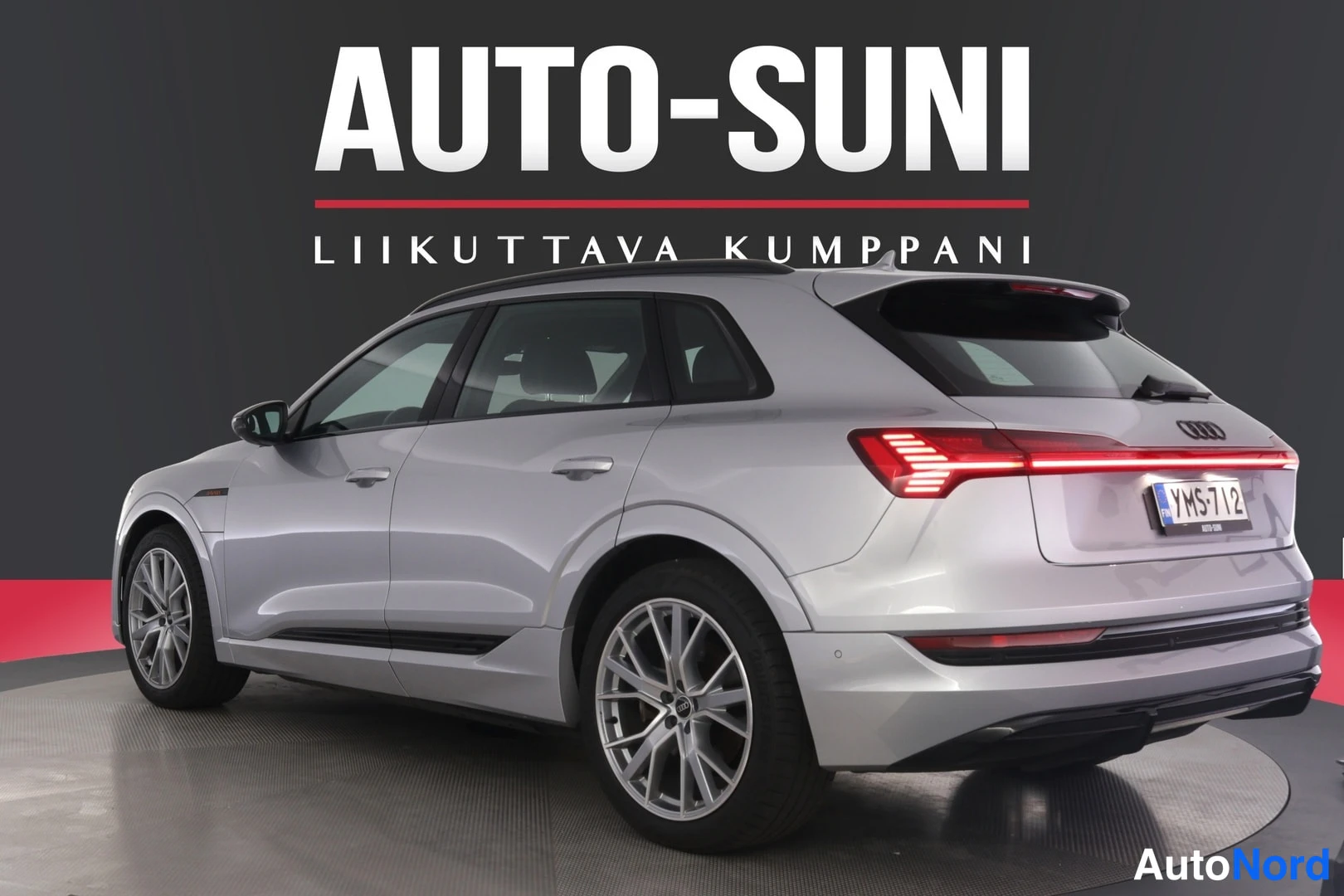 Takaviisto: Audi e-tron takaviisto oikealta kuvattuna: vaaleanhopea korin sivu, kevytmetallivanteet ja punainen takavalo-LED-rima näkyvät.