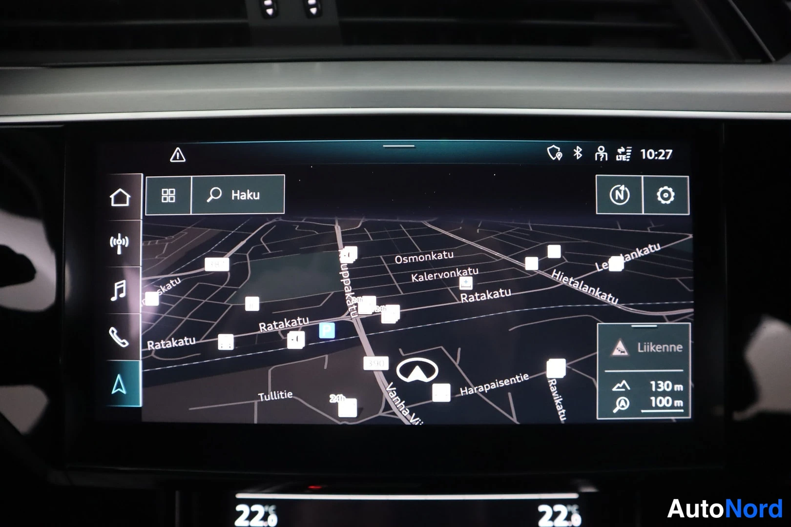 Yksityiskohta: Audi-auton keskikonsolin infotainment-näyttö näyttää karttanavigaatiota, jossa on katunimiä kuten Ratakatu ja Omonkatu, sekä ilmastointiarvot 22,0 molemmin puol
