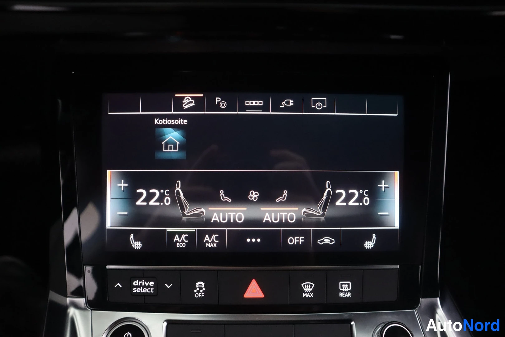 Yksityiskohta: Auton ilmastointipaneelin näyttö näyttää molempien puoltien lämpötilan 22,0, AUTO-toiminnan, A/C Eco- ja Max-painikkeet sekä drive select -painikkeen.