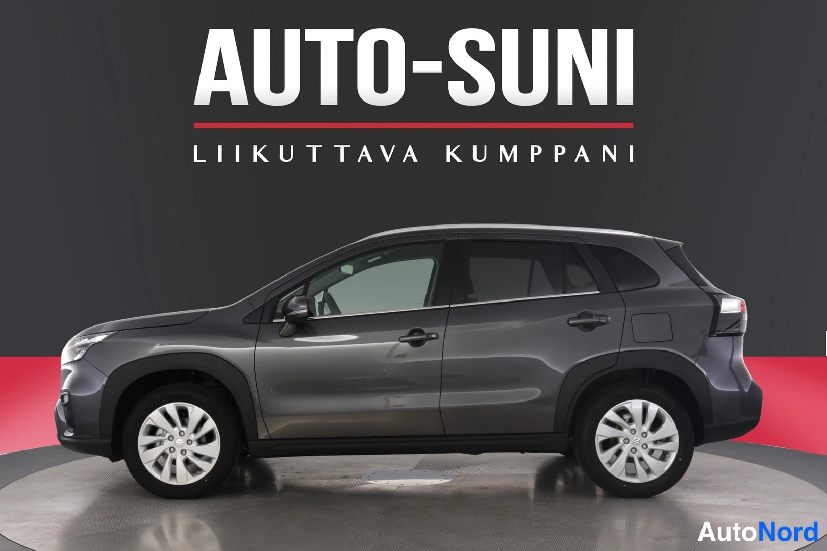 Sivulta: Audi S-Cross sivulta studiotelan päällä: harmaa koripaneeli, mustat kaaripaneelet ja kaksiosainen renkaan pulttipeili.