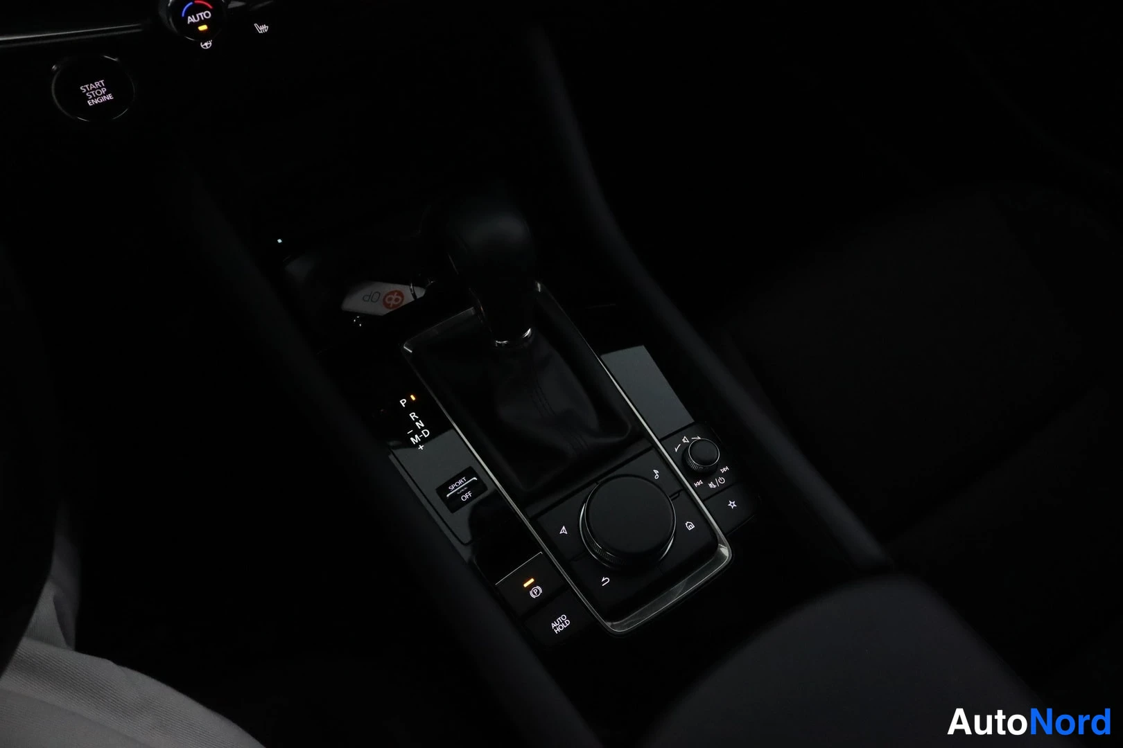 Etuviisto: interior shot of car center console and dashboard area in dark lighting