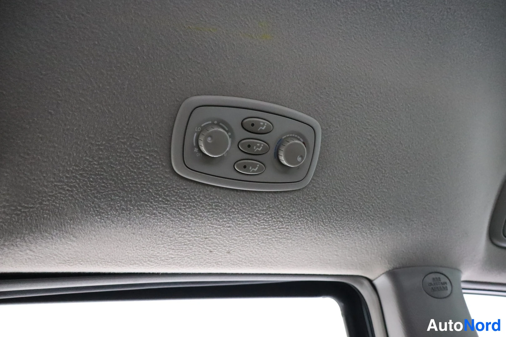 Muu: Toyota Sienna -kohdekuva 4: lähikuva kattoon integroitusta säätöpaneelista harmaassa kattoverhouksessa; kaksi nuppia (LO/OFF/HI) ja kolme painiketta näkyvät.