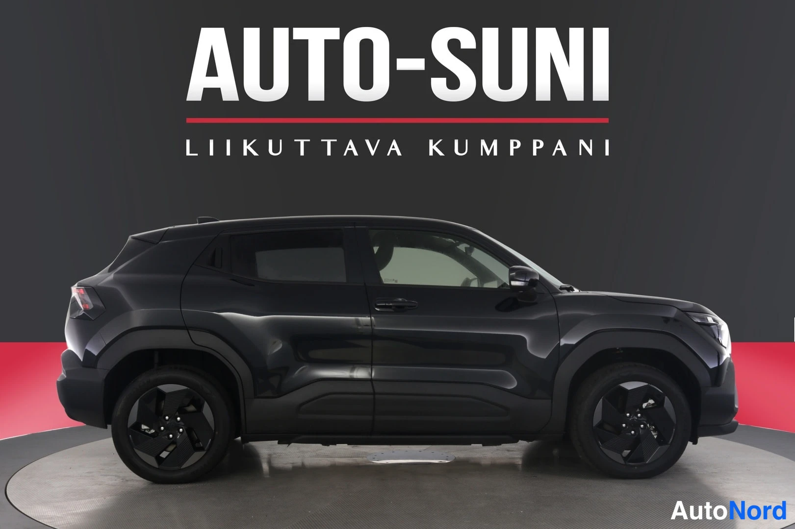 Sivulta: Mustan Suzuki Vitaran sivuprofiili vasemmalta katsottuna studio-oloissa, Auto-Sunin taustalla.
