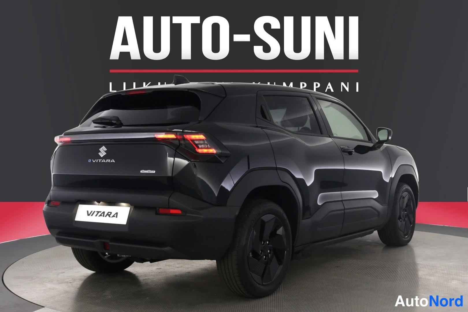 Takaviisto: Mustan Suzuki Vitaran takakulma oikealta, takavaloja ja VITARA-tunnusta näkyen, Auto-Sunin taustalla.