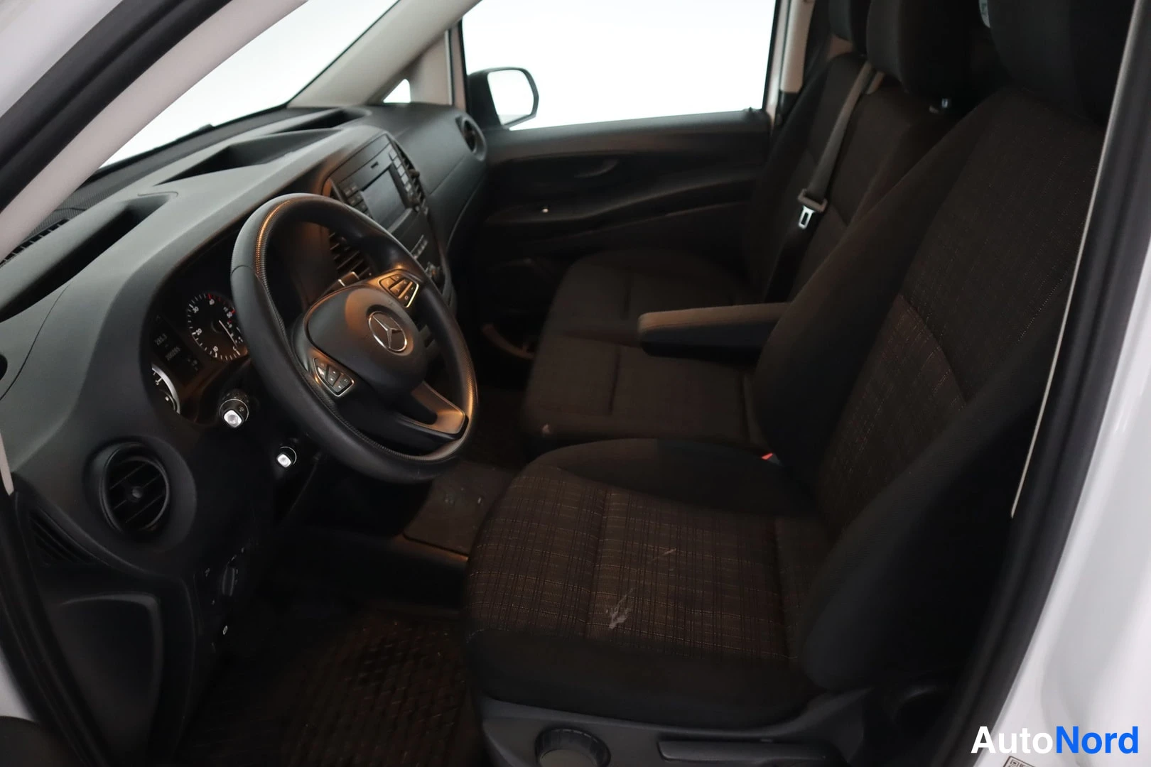 Muu: Sivulta kuvattu ohjaamo: Mercedes-volttiratti, kojelauta, radio ja tummat kangasistuimet.