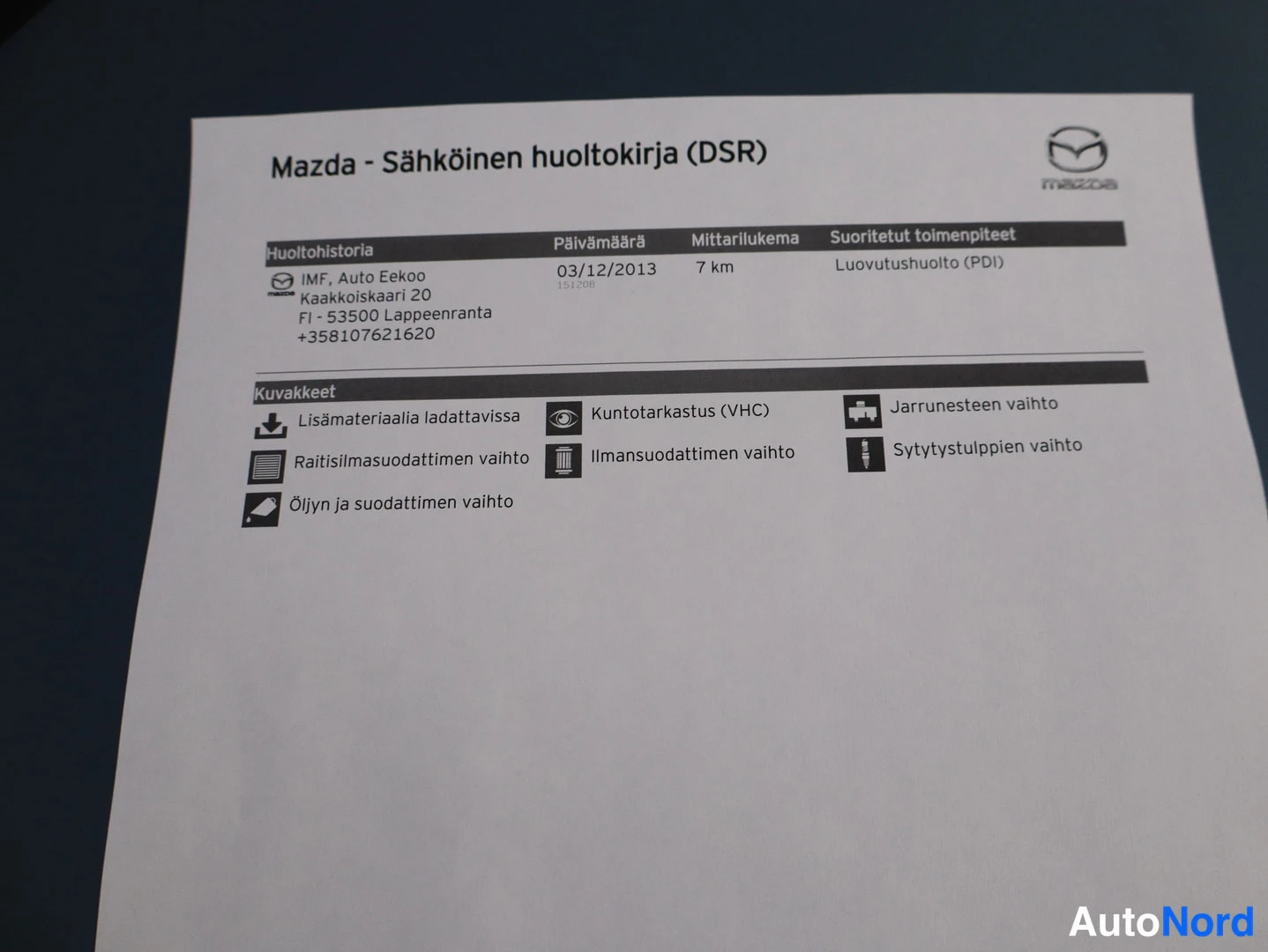 Sivulta: Mazdan sähköinen huoltokirja (DSR) -tuloste, jossa huoltohistoria-merkintä 03.12.2013, mittarilukema 7 km ja luovutushuolto (PDI).