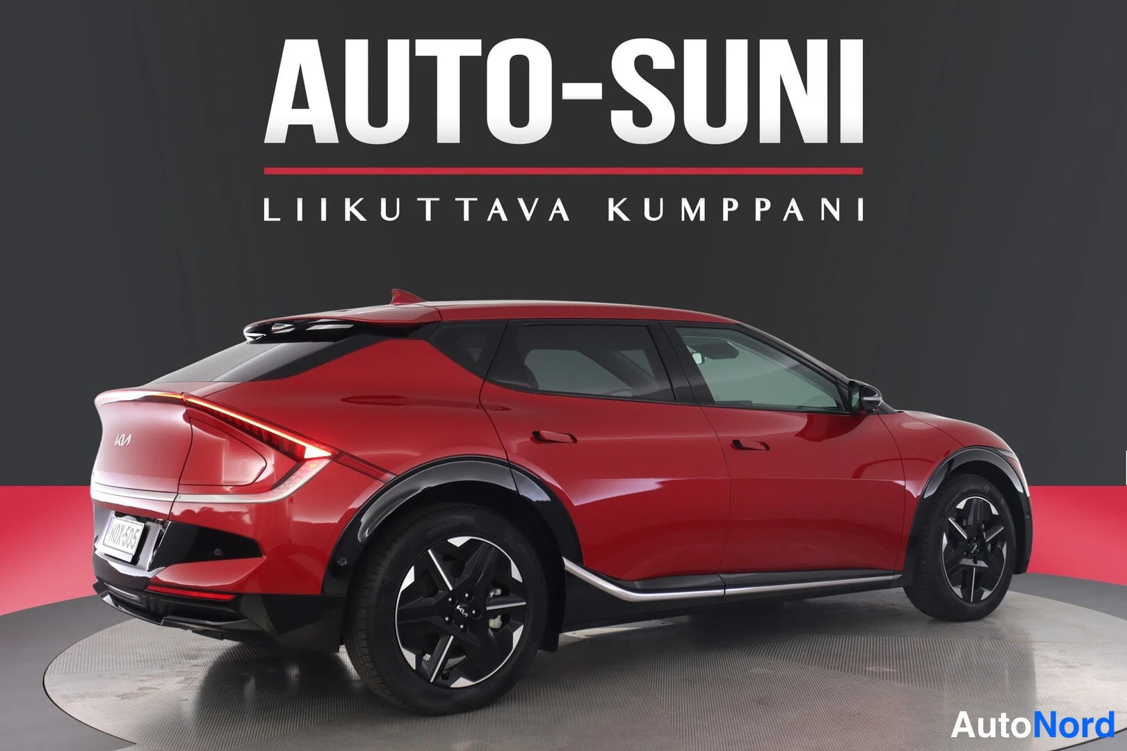 Takaviisto: Punainen Kia EV6 takaosa kolmivartaloasennossa vasemmalta nähtynä, rekisterikilpi.