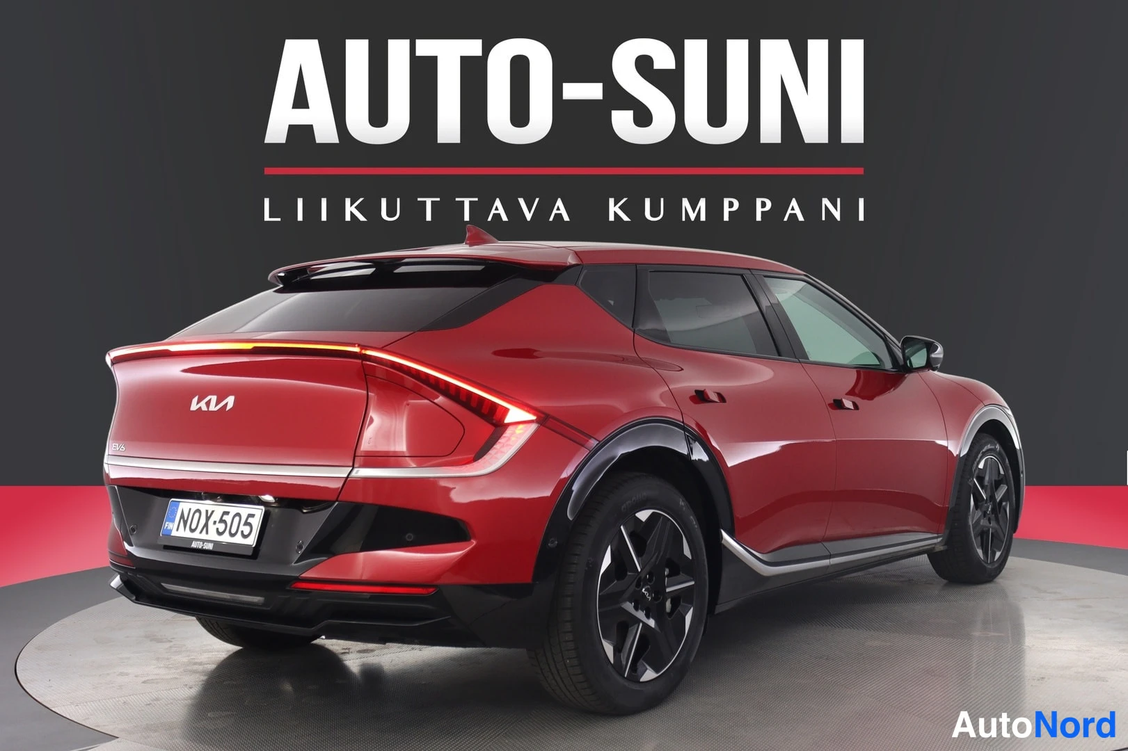 Takaviisto: Punainen Kia EV6 takaosa kolmivartaloasennossa vasemmalta nähtynä, perävasa.