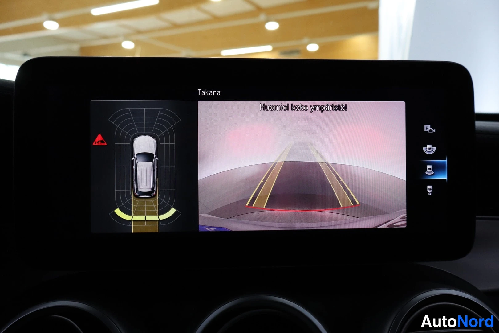 Ohjaamo: Center infotainment screen displaying the 360-degree parking assist system. The left side shows a top-down vehicle graphic with proximity sensors indicating obs