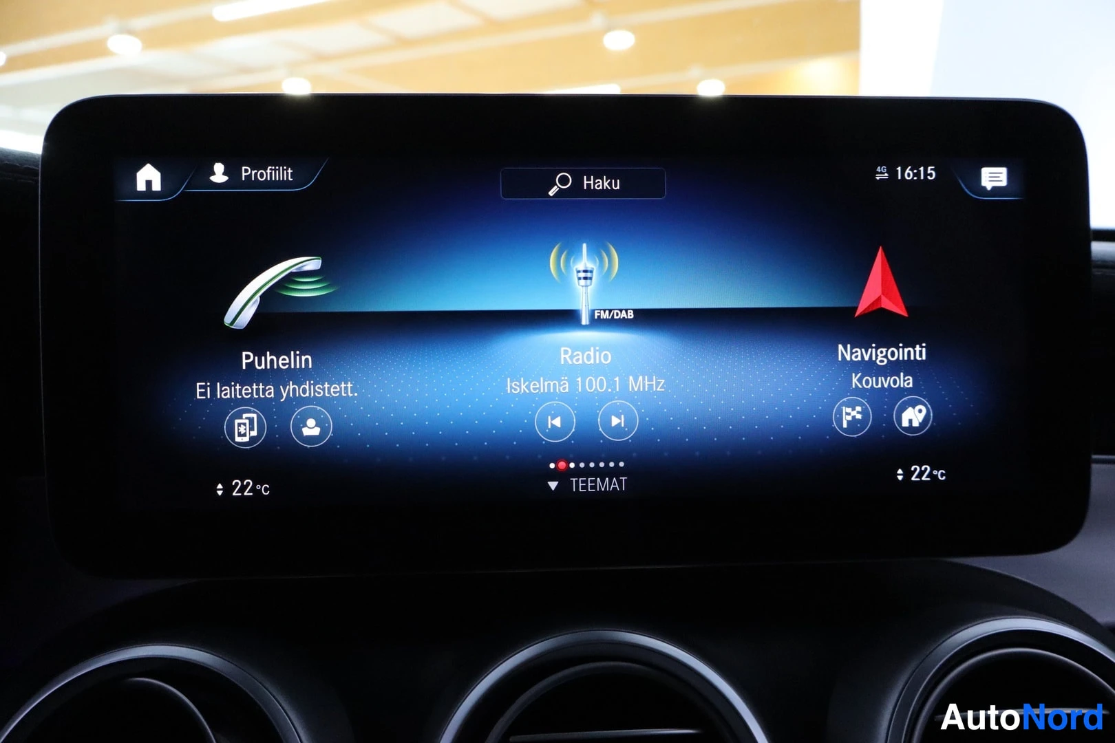 Ohjaamo: Infotainment touchscreen showing the home menu with three main widgets: 'Puhelin' (Phone) status 'Ei laitetta yhdistett.' (No device connected), 'Radio' tuned t