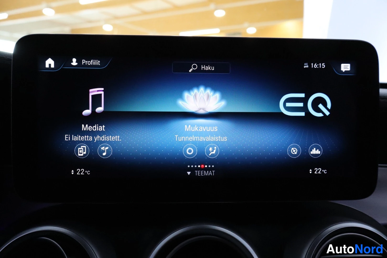 Ohjaamo: Center infotainment display showing an ambient lighting theme named 'Mukavuus Tunnelmavalaistus' with a flower graphic. Other visible options include 'Mediat' (