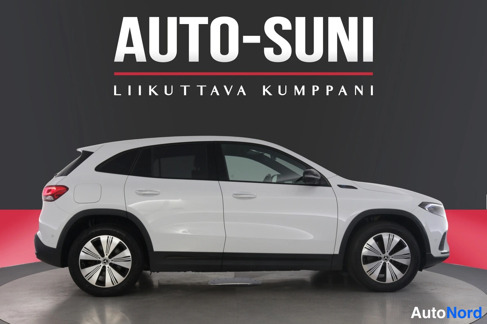 Etuviisto, nokka oikealle: Valkoinen Mercedes-Benz EQA -maasturin sivunäkymä studiotaustaa vasten, Auto-Suni-mainosteksti taustalla.