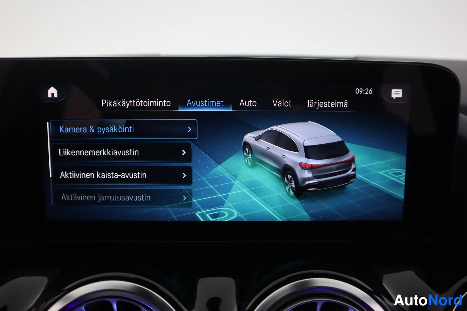 Muu: Kesk näyttö Avustimet-valikossa, jossa kohteet Kamera & pysäköinti, Liikennemerkkiaustin, Aktiivinen kaista-austin ja Aktiivinen jarrutusavustin sekä kuva autos