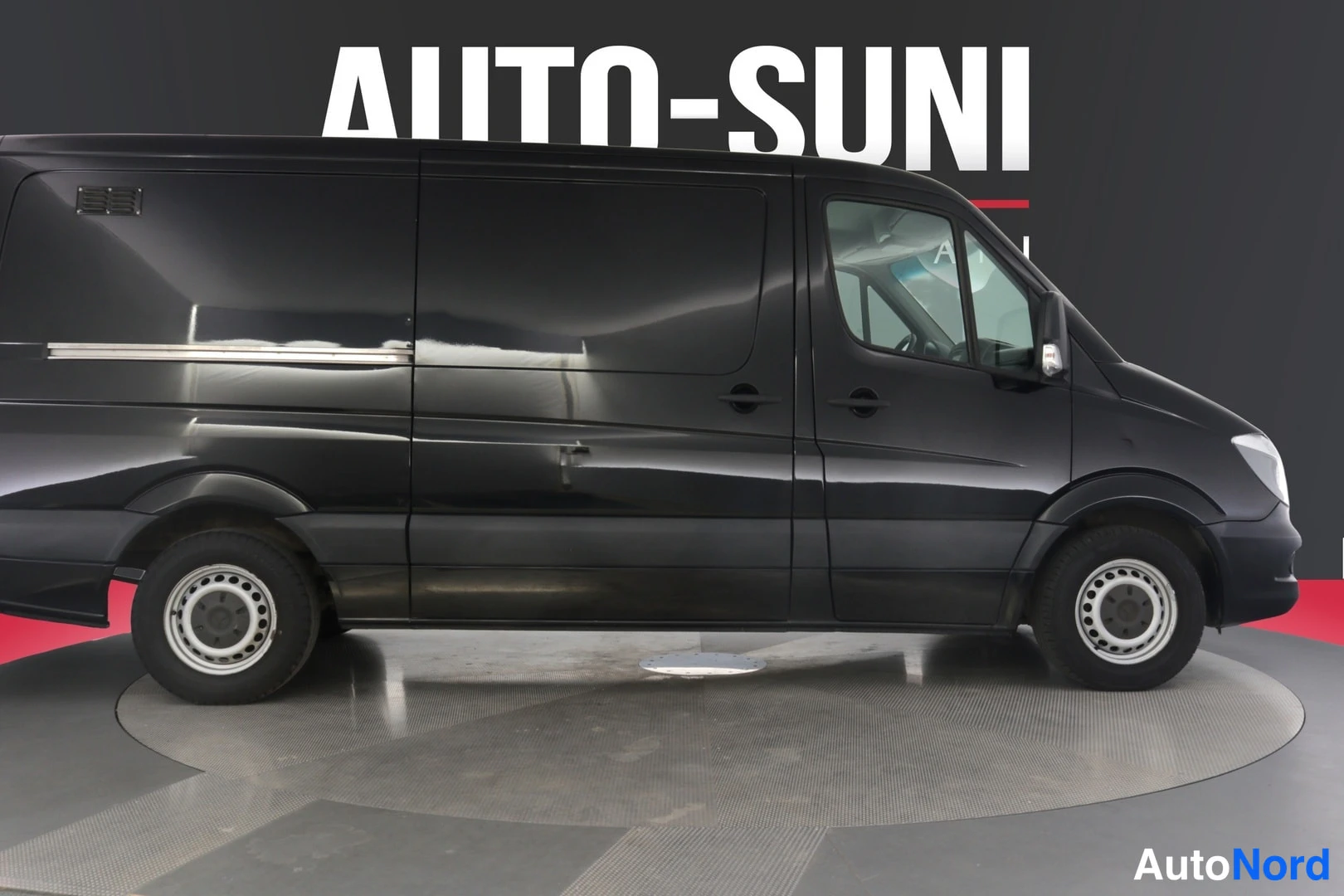 Sivulta: Mustan Mercedes-Benz Sprinter -pakettiauton kylki sivusta studiossa.