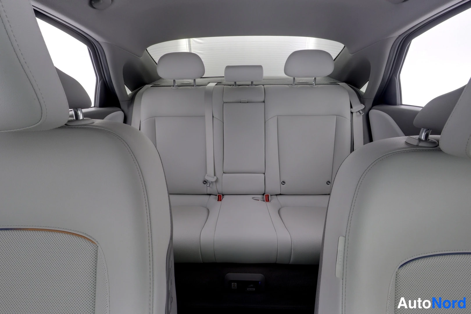 Takaistuimet: Rear seating area showing three seatbacks with headrests and seatbelt anchors