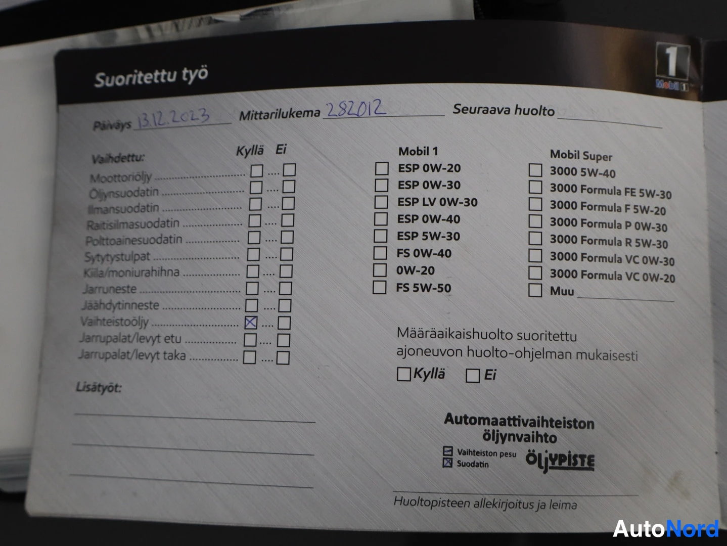 Yksityiskohta: Huoltokirjan sivu 'Suoritettu työ', päiväys 13.12.2023, mittarilukema 282012, vaihteistoöljy rastitettu, Öljypiste-leima.