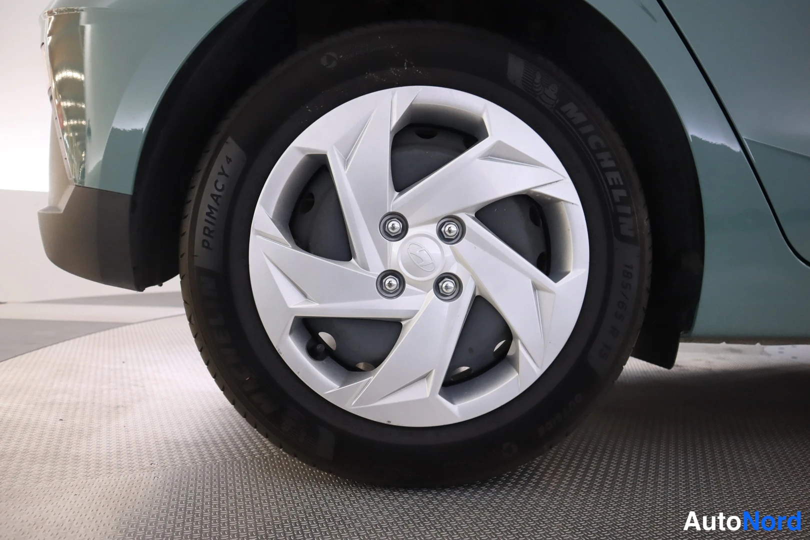 Yksityiskohta: Close-up of the front wheel featuring a white multi-spoke alloy rim and a Michelin Primacy 4 summer tyre.