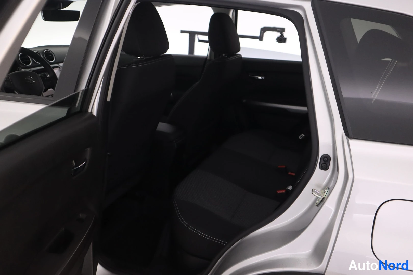 Muu: Suzuki Vitaran takapenkku ja etumatkustajan selkänoja takaovesta katsottuna, korin valkoinen maali näkyy oviaukossa.