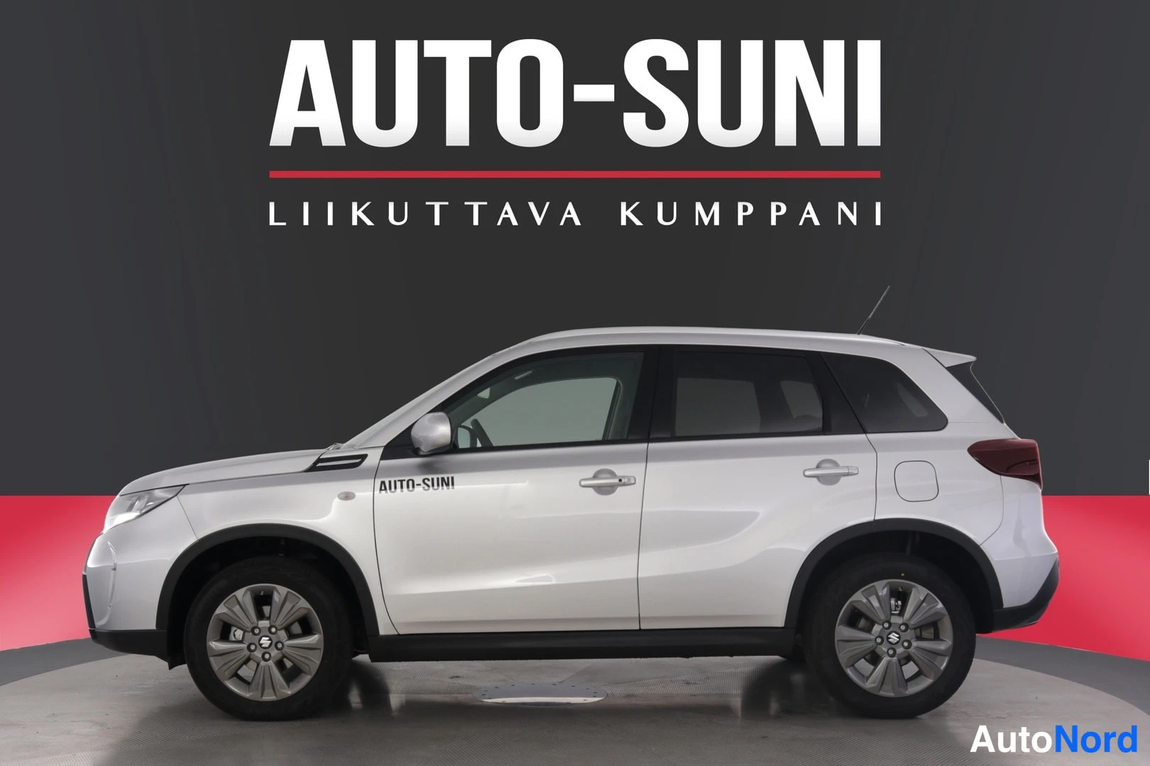 Sivulta: Sivukuvassa valkoinen Suzuki-voltti esillä kirkkaassa studioympäristössä. Autossa on hopeiset vanteet ja tummat ikkunakehykset.