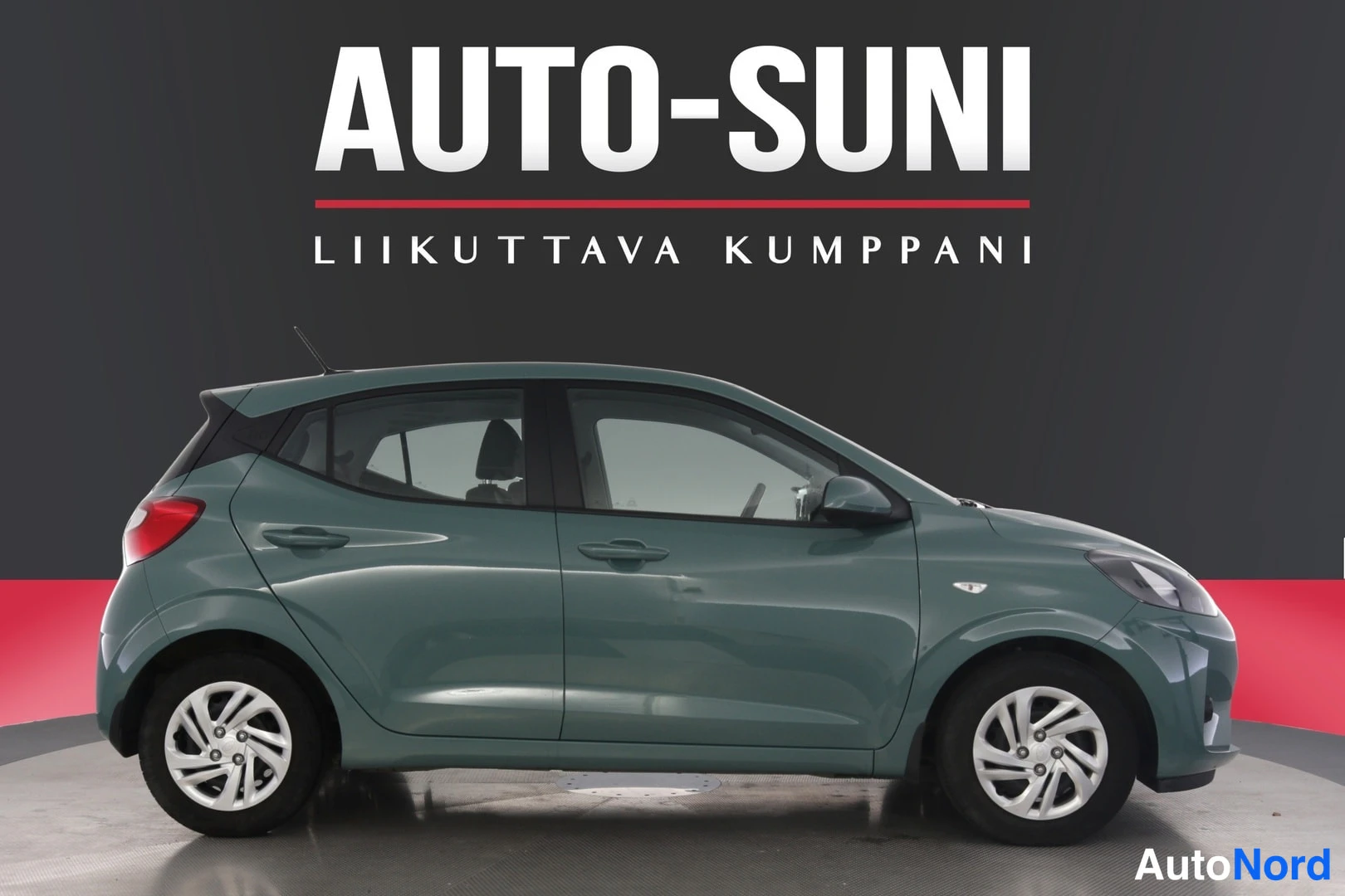 Sivulta: Samoin vihreä Hyundai i10 sivukuvassa. Kuvassa näkyy auton oikea puoli, mukaan lukien pyörät ja ovien kahvat.