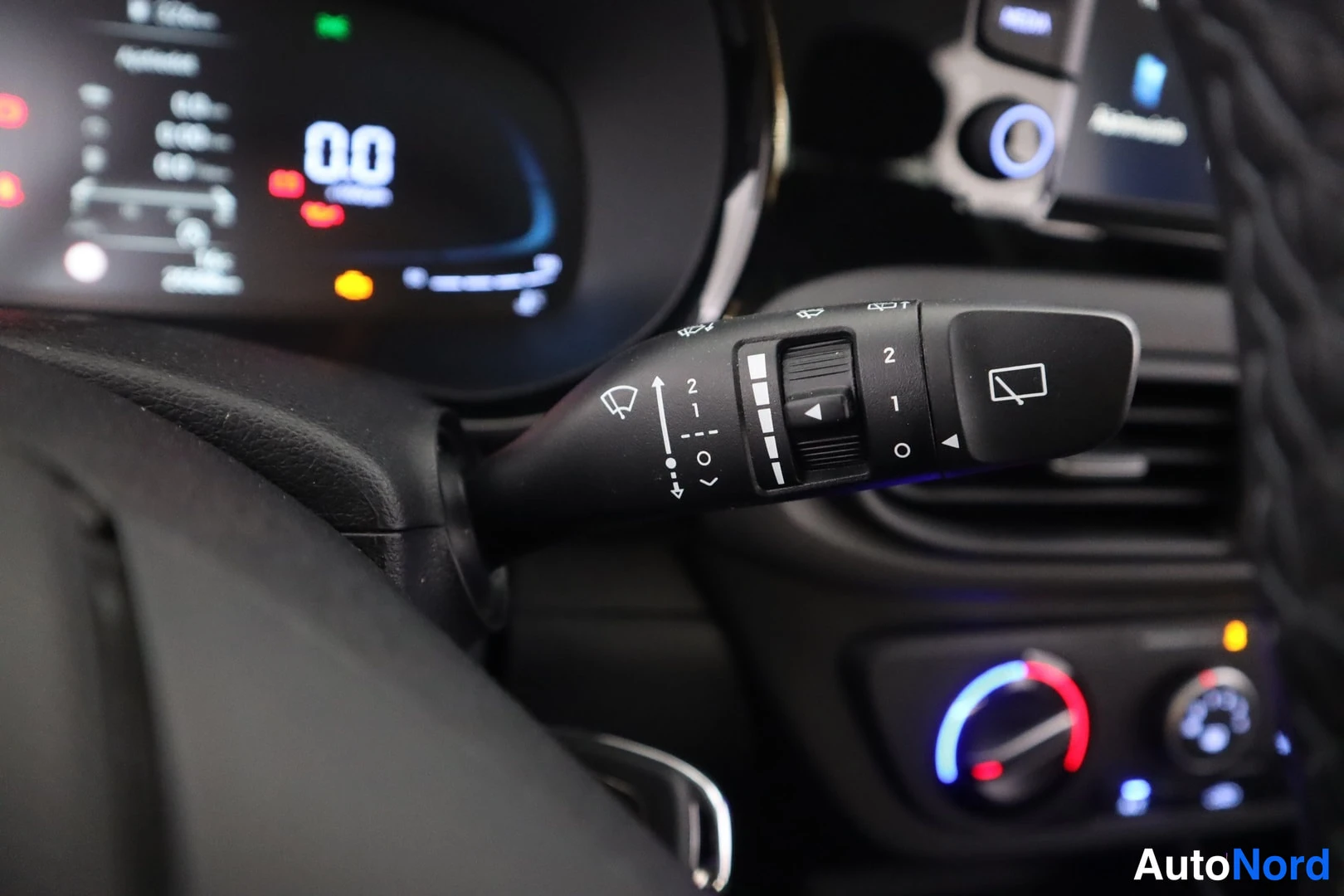 Etuistuimet: Rear-view camera switch on wiper stalk with icons for high/low speed (2-1) and auto wash, next to illuminated instrument cluster.