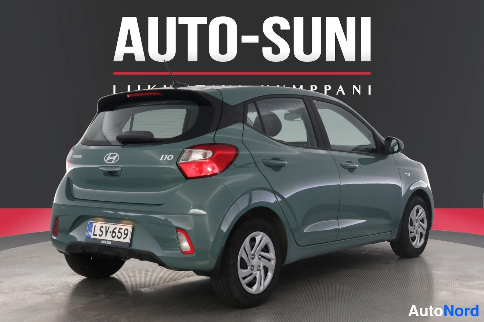 Takaviisto: Vihreä Hyundai i10 -malli takana ja oikealta kulmassa. Takaosaan kuuluu Hyundai-logo ja mallimerkintä 'i10'. Auton rekisterinumero on.