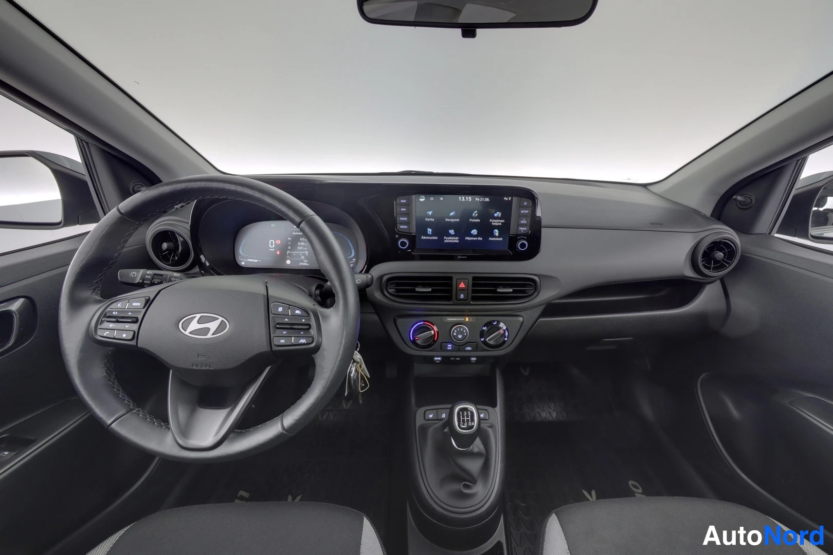 Etuistuimet: Interior dashboard shot of the car cabin. Visible elements include the steering wheel with mounted controls, a central infotainment display screen (Android Auto