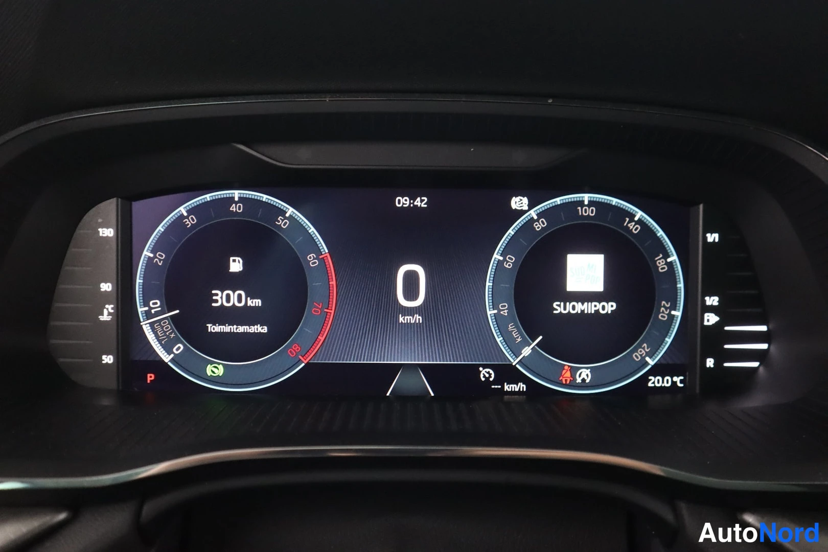 Muu: Digitaalinen mittaristo näytetään ajovaiheessa. Vasemmalla polttimäärämittari näyttää 300 km toimintamatkaa (Toimintamatka) ja oikealla nopeusmittari, jonka ylä