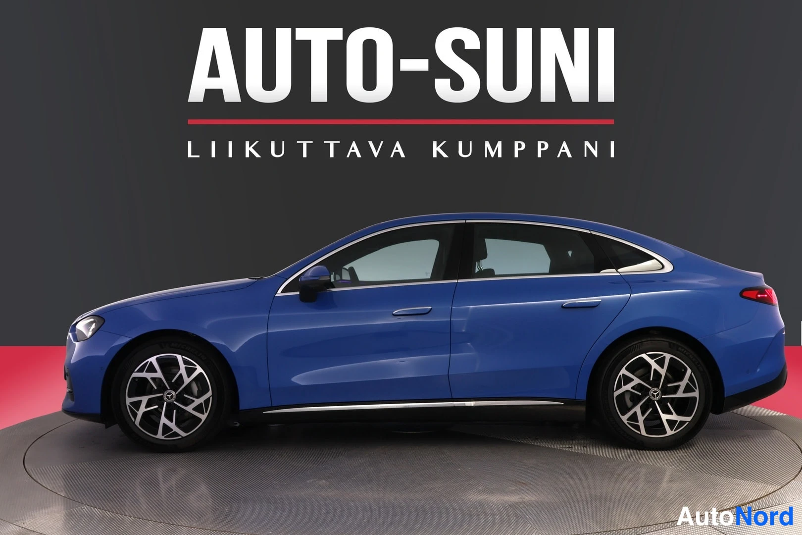 Sivulta: Auton kylki- ja keulaosa näkyvä kuva: sininen Mercedes-Benz, tumma tausta ja AUTO-SUNI-mainoskuvitus.