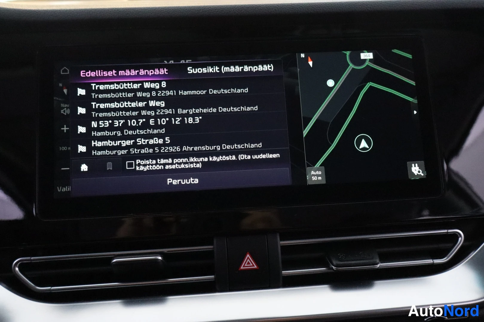 Muu: Infotainment-näytön navigaatiovalikko, jossa lista aiemmista määränpäistä Saksassa.