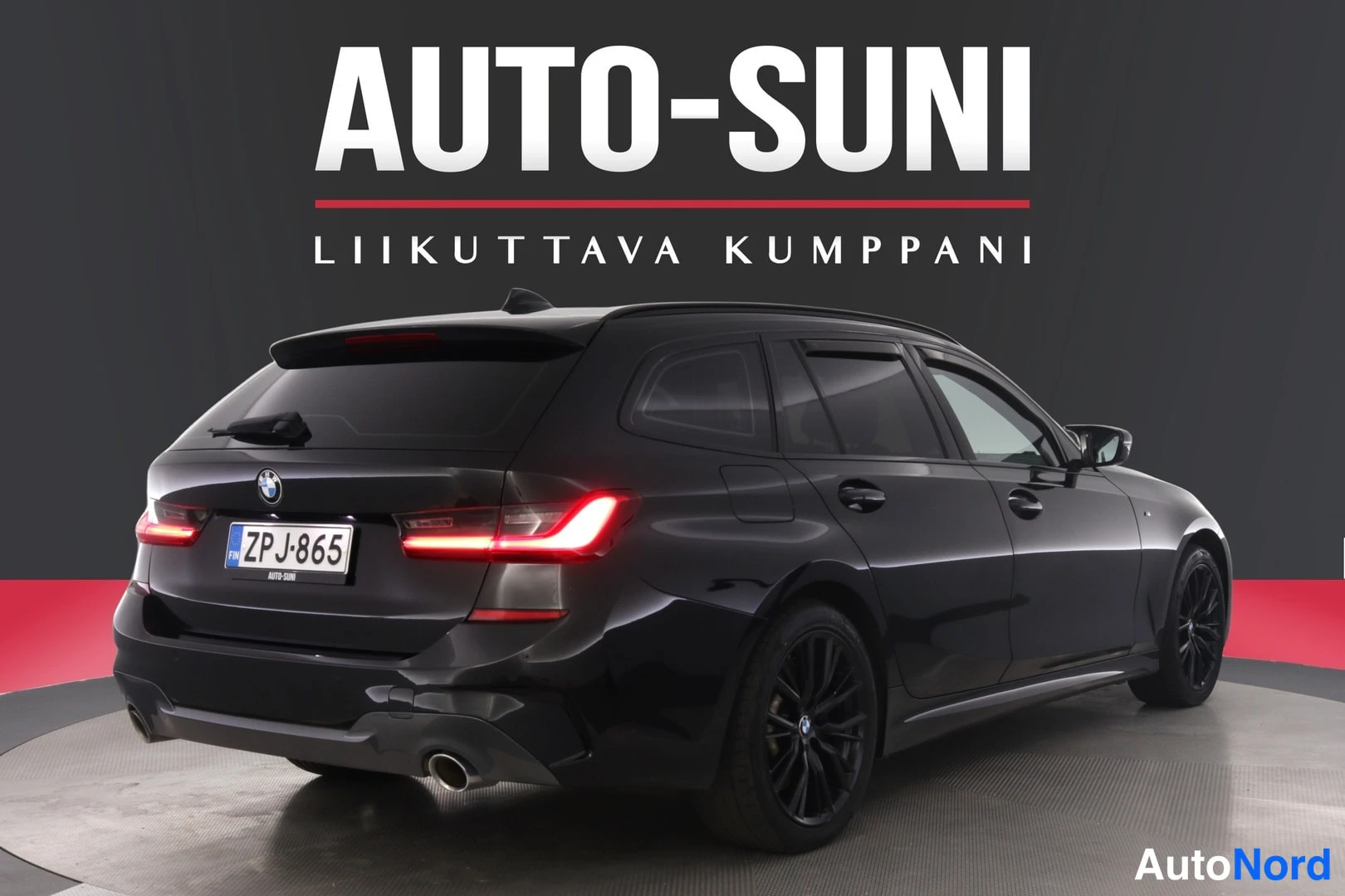 Takaviisto: BMW:n farmarimallin takaosa ja vasen kylki mustassa värissä, rekisterikilpi ZP J-865, mustat vanteet, AUTO-SUNI-tausta.