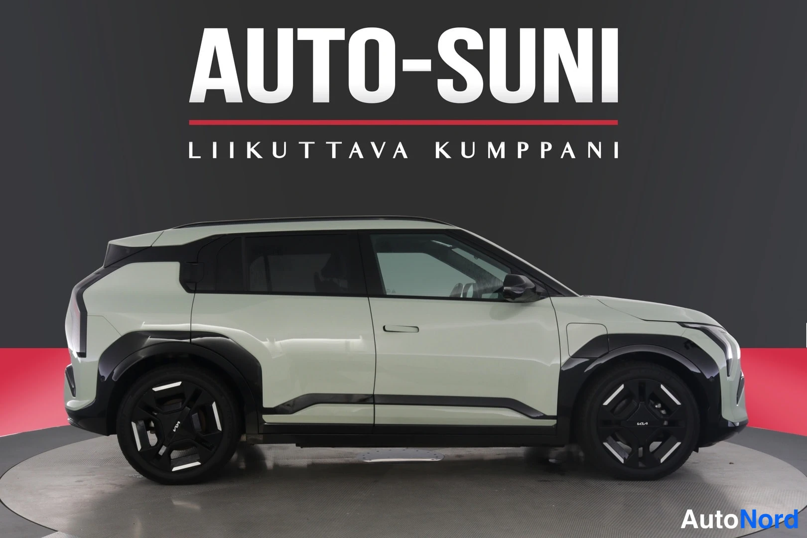 Sivulta: Vaaleanvihreä Kia EV3 sivuprofiilista myymälätilassa
