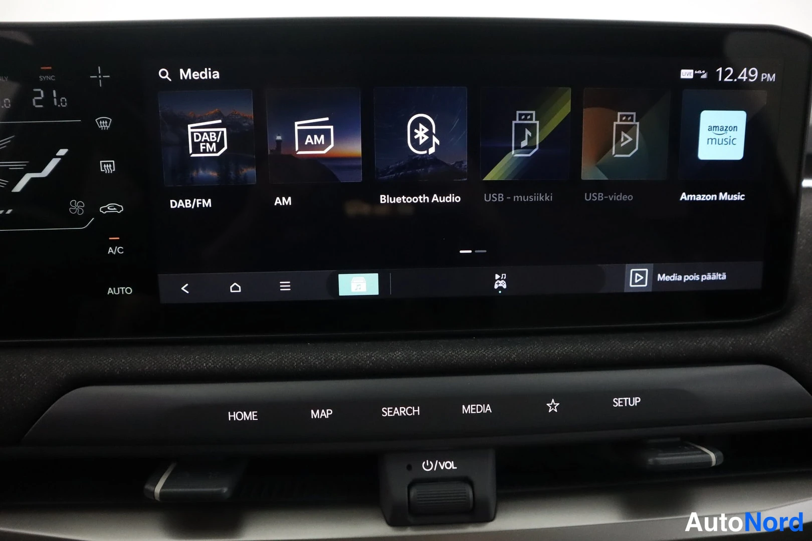 Muu: Kia EV3:n infotainment-näyttö näyttää mediavalikon vaihtoehtoina DAB/FM, AM, Bluetooth Audio, USB-musiikki, USB-video ja Amazon Music; alapuolella HOME-, MAP-,